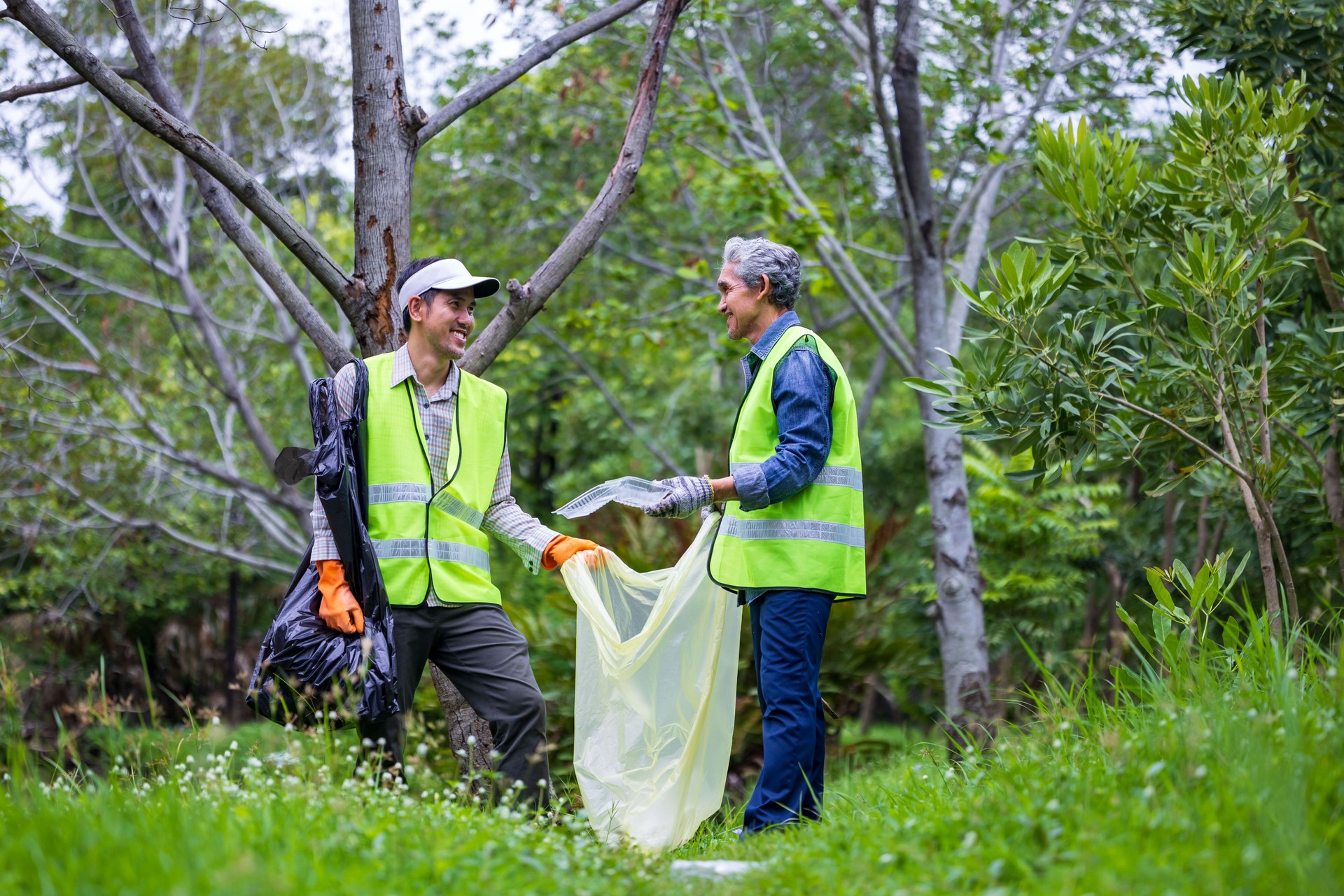 Team volunteer worker group enjoy charitable social work outdoor in cleaning up garbage and waste separation project at the park or natural forest for community service and recycle concept