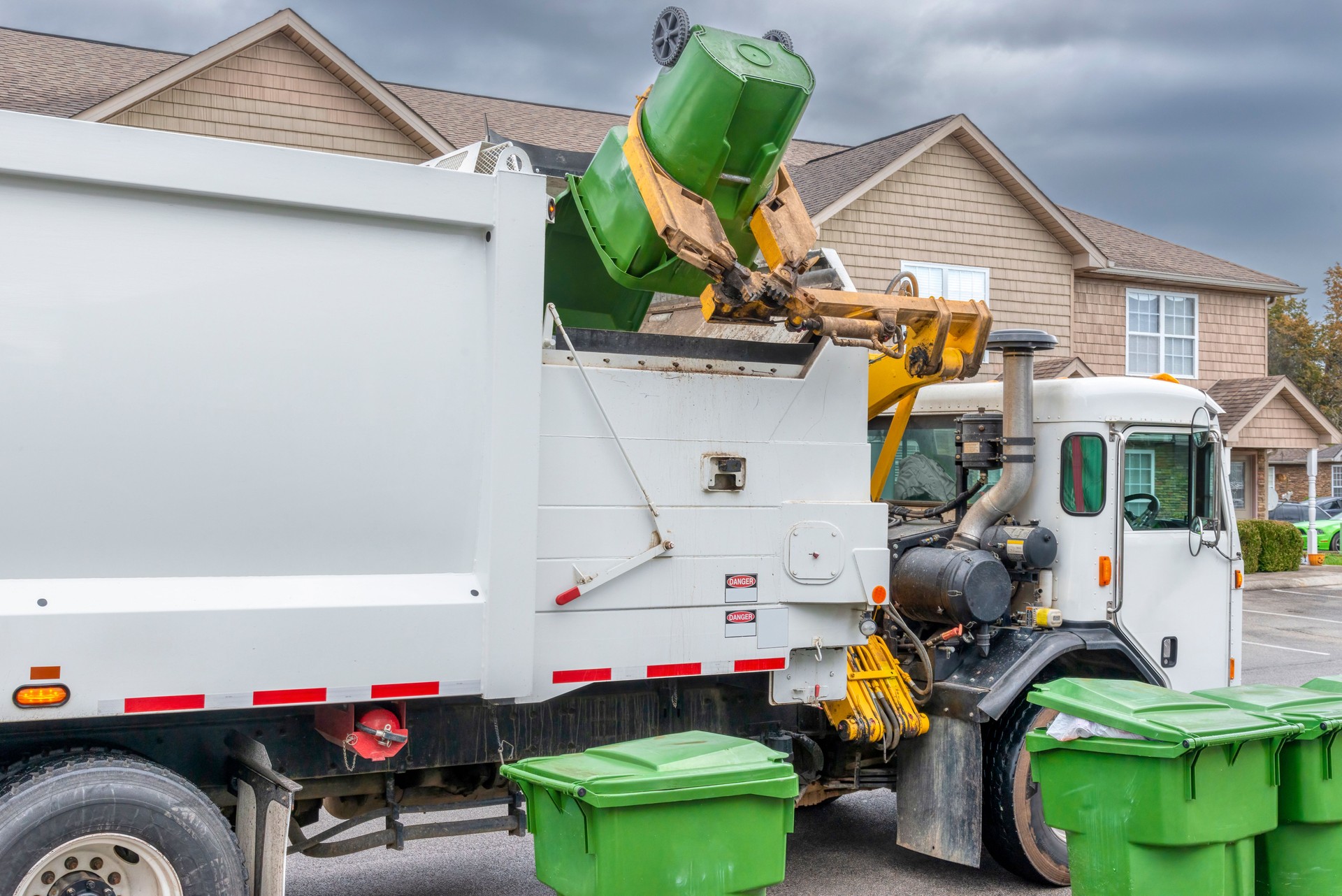 Mechanical Arm On Modern Trash Truck Dumps Garbage Without Help